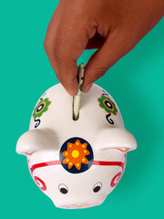 kid putting a banknote inside a piggybank