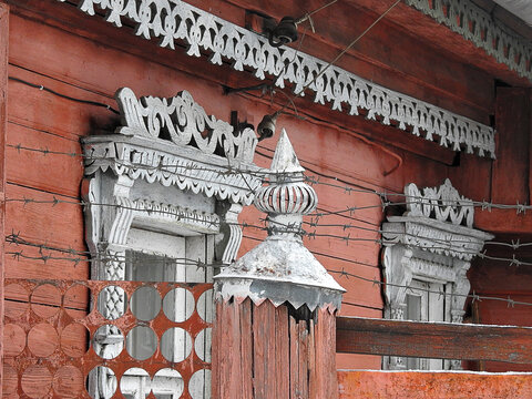 Beautiful russian wooden house behing the fence with barbed wire