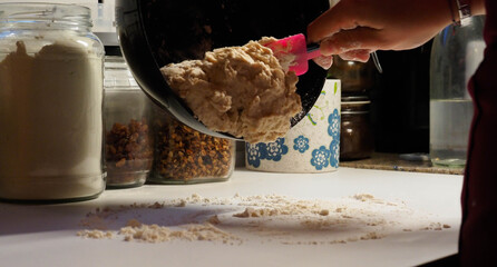 hands of a young woman making a bread dough