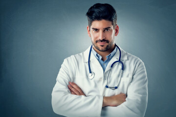 Portrait of male doctor standing at isolated background