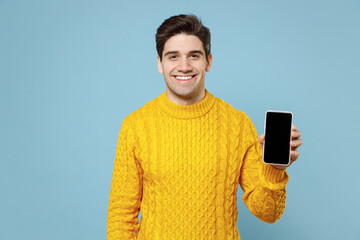 Young caucasian gladden happy smiling student man in casual knitted yellow sweater hold in hand...