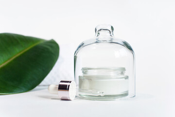 Natural organic cream jar with a green leaf on a light background. copy space. Natural organic product, Beauty and Spa concept