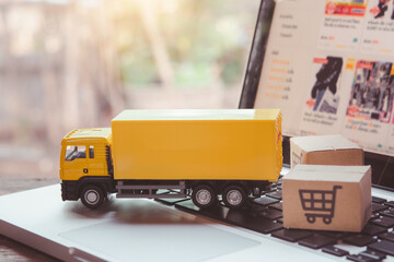 Logistics, and delivery service - Truck and paper cartons or parcel with a shopping cart logo on a...
