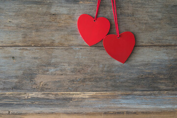 Valentine card background. Two red hearts on wooden background. Space for space