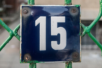 Weathered grunge square metal enamelled plate of number of street address with number 15