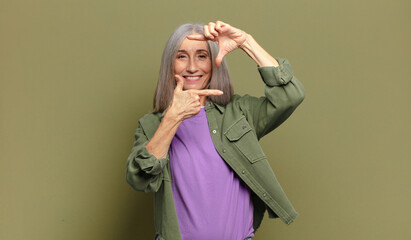 senior woman feeling happy, friendly and positive, smiling and making a portrait or photo frame...