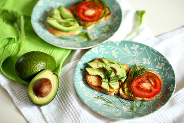 Toast with tomatoes and pesto and sliced avocado on toast bread