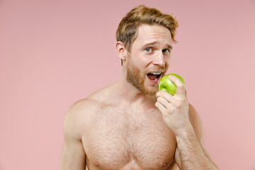 Handsome bearded naked young man 20s years old perfect skin hold eating green fresh apple fruit...