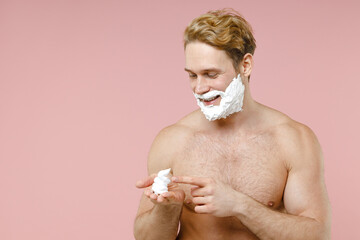 Smiling bearded naked young man 20s years old perfect skin face covered with shaving foam isolated on pastel pink color background studio portrait. Skin care healthcare cosmetic procedures concept.