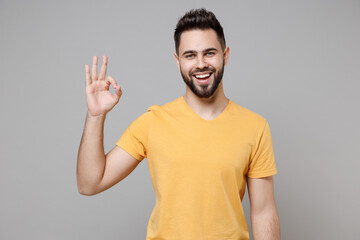 Young caucasian european happy bearded satisfied attractive man 20s wearing casual yellow basic...