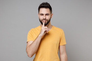 Young caucasian bearded happy secret serious student man 20s wear casual yellow basic t-shirt...
