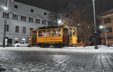 Old tram on the streets of medieval town with stone pavement at night. The Last Tram of Vyborg,...