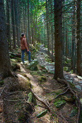 Obraz premium Man with hiking equipment walking in forest