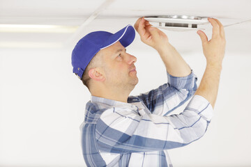 contractor working on air vent in the ceiling