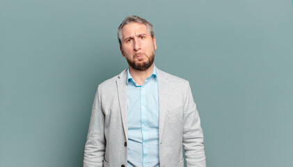 adult businessman feeling sad and whiney with an unhappy look, crying with a negative and...
