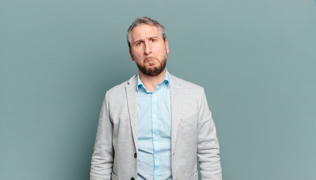 adult businessman feeling sad and whiney with an unhappy look, crying with a negative and frustrated attitude