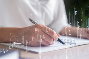 A woman trader in formal wear writing down some ideas to research stock market to proceed right...