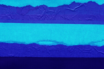 Blue and violet torn paper collage close-up. Texture made from various paper and cardboard parts. Damaged old paper background. Vintage blank wallpaper. Material design backdrop.