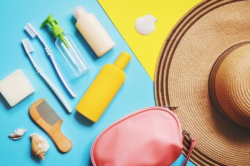 Luggage and summer travel accessories bag, toiletries kit. Flat lay composition object photography. Soap bar, toothbrushes, empty bottles for cosmetics, sunscreen cream, bag and hat - obrazy, fototapety, plakaty