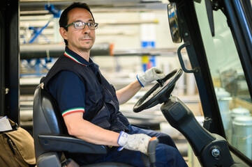 A construction worker driving a forklift in an industrial plant © Minerva Studio