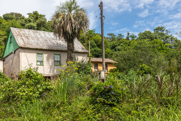 Fototapeta na wymiar Small house in enxaimel style, dirty road with flowers and plants around