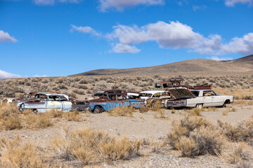 Junkyard group of abandoned old rusty cars sits in the desert rotting away