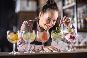 Broad selection of gin tonic drinks made on a bar by a good-looking barmaid