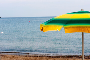 A beach umbrella opened near the shore at sunset. Vacation, resort, concept, conceptual.