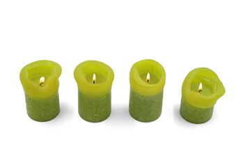 different sized burning green candles on a white background, top view