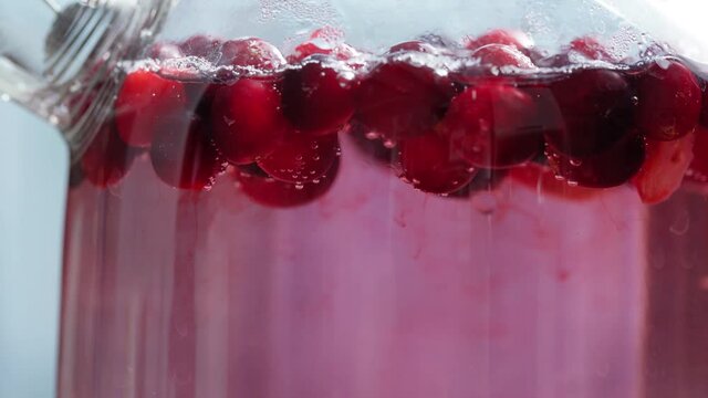 brewed bcranberry berries filled with boiling water turn the water red. rich therapeutic healthy decoction of viburnum berries. close - up macroerries color the water. close - up macro