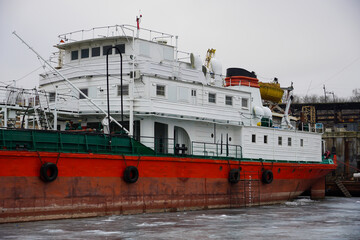 Old rusty motor ship. Volgograd. Krasnoarmeysky Zaton, wintering of ships on a frozen river.