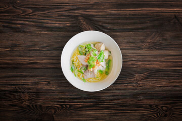 Pork noodles with meat ball on wooden background