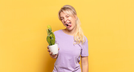 blonde woman with cheerful, carefree, rebellious attitude, joking and sticking tongue out, having...