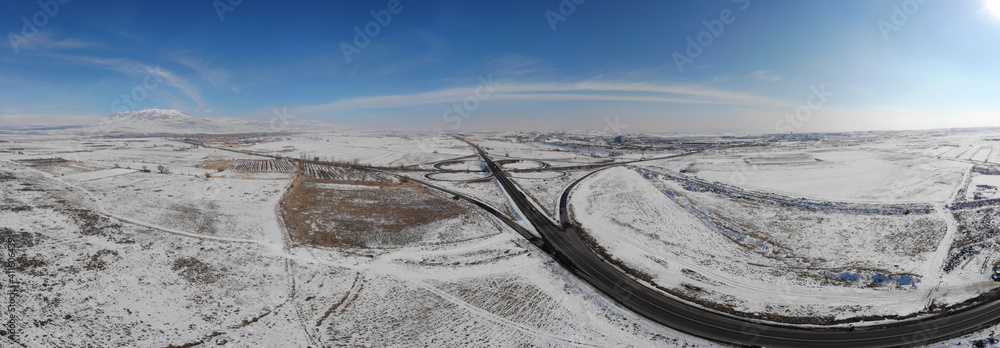 Wall mural road with snowy landscape view from a drone