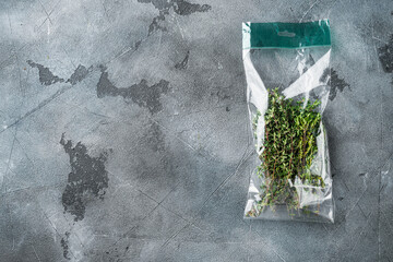 Thyme in plastic bag, on gray background, top view flat lay  , with copyspace  and space for text