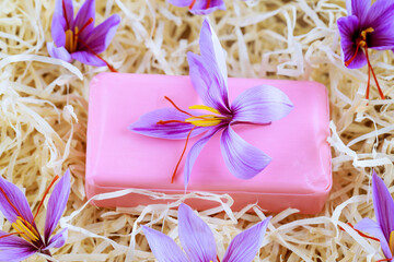Obraz na płótnie Canvas Saffron soap and beautiful purple crocus flowers on wooden shavings. The use of saffron in ntural osmetology.