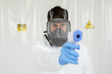 Doctor wearing protective mask ready to use infrared forehead thermometer to check body temperature...