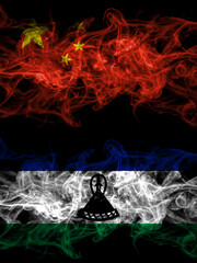 China, Chinese vs Lesotho smoky mystic flags placed side by side. Thick colored silky abstract smoke flags.