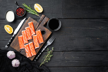 Fresh Crab meat stick surimi , on wooden cutting board, on black wooden table background, top view flat lay  , with copyspace  and space for text