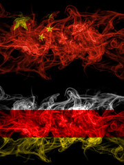 China, Chinese vs South Ossetia smoky mystic flags placed side by side. Thick colored silky abstract smoke flags.