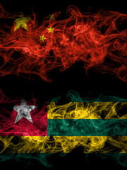 China, Chinese vs Togo smoky mystic flags placed side by side. Thick colored silky abstract smoke flags.
