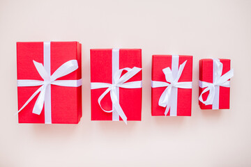 Red gift boxes of various sizes tied with a white satin ribbon. High quality photo
