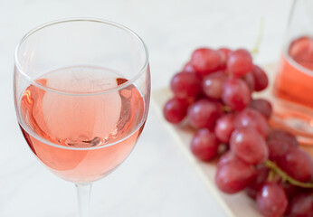 Glass of rose wine and grapes and bottle