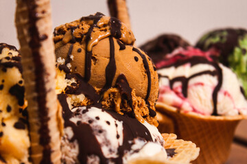 Close-up of an ice cream hat dipped in chocolate, in front of another ice cream.