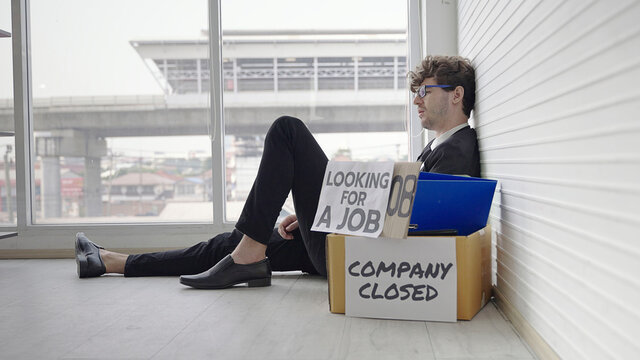 The dismissed company employee was sad. He subsided, wanting to be exhausted by the glass wall.