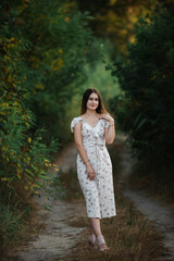 Blonde girl in summer light dress in summer outdoors