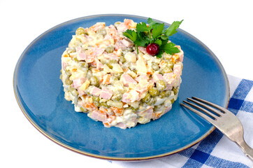 Russian vegetable salad with peas and mayonnaise on blue plate