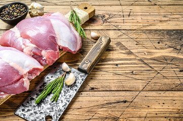 Raw boneless Turkey thigh fillet on a chopping Board. wooden background. Top view. Copy space