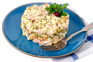 Russian vegetable salad with peas and mayonnaise on blue plate