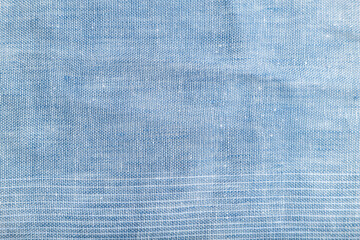 Fragment of smooth blue linen tissue. Top view, natural textile background.